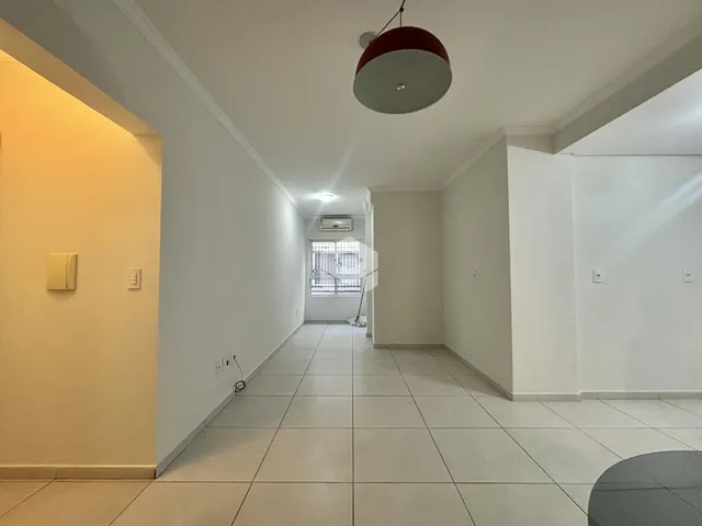Vista do corredor interno de uma residência com piso de cerâmica clara.