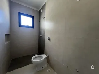 Foto de um banheiro moderno com paredes claras e piso de cerâmica.