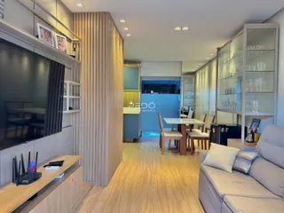 Sala de estar e jantar moderna com piso de madeira clara e móveis planejados.