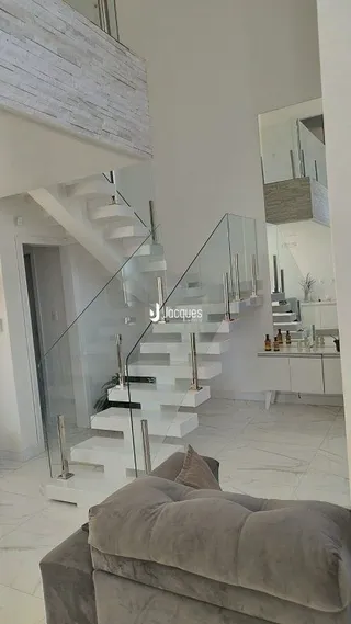 Vista de um corredor com escadaria em uma residência.