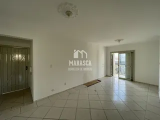 Ambiente interno de uma sala com piso de cerâmica e paredes brancas.