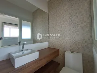 Vista de um banheiro com bancada de madeira e vaso sanitário em Lajeado.