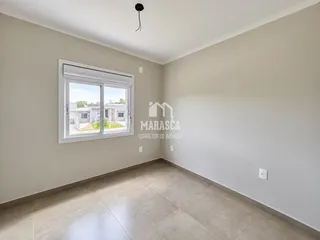 Sala de estar com piso de cerâmica clara e paredes neutras.