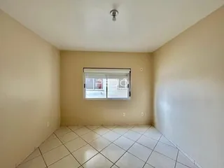 Quarto interno com piso de cerâmica claro e janela.
