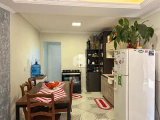 Foto de uma sala de jantar com mesa de madeira e piso estampado.