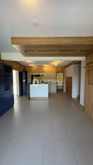 Hall de entrada com piso claro e teto de madeira.