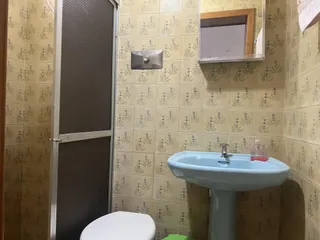 Foto de um banheiro com revestimento de azulejos claros e pia branca.