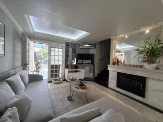 Sala de estar moderna com lareira e grandes janelas em Lajeado.