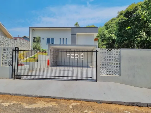 Fachada moderna de uma casa com muro e portão de ferro na Lajeado.