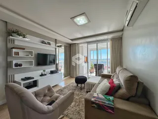 Sala de estar moderna com grandes janelas de vidro e vista externa.