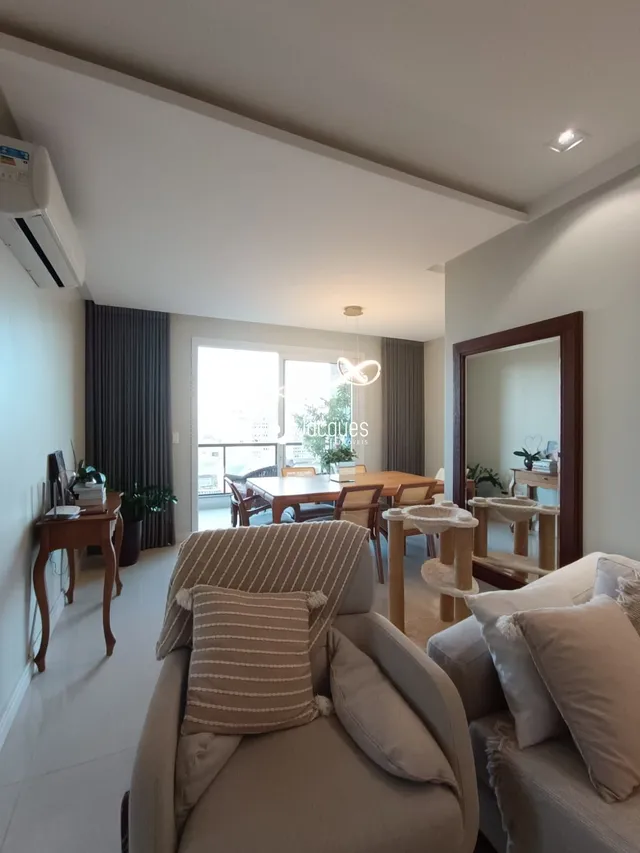 Sala de estar com sofá e janela de vidro em um imóvel.