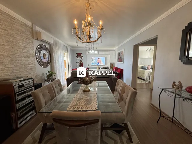 Uma sala de jantar com mesa de vidro e cadeiras estofadas.