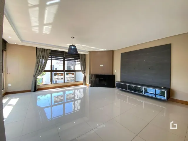 Sala de estar ampla com piso de porcelanato claro e parede de destaque moderna.