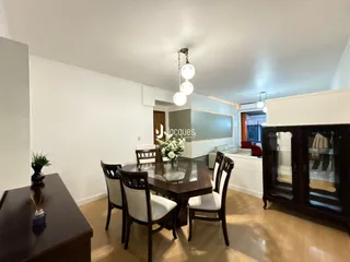 Foto de uma sala de jantar com mesa de madeira e cadeiras em um apartamento.