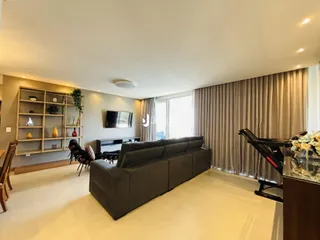 Sala de estar com sofá e estante em um apartamento no Brasil.