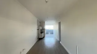 Corredor interno de uma residência com piso de madeira clara.