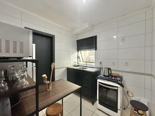 Cozinha com armários escuros e piso de cerâmica branca.