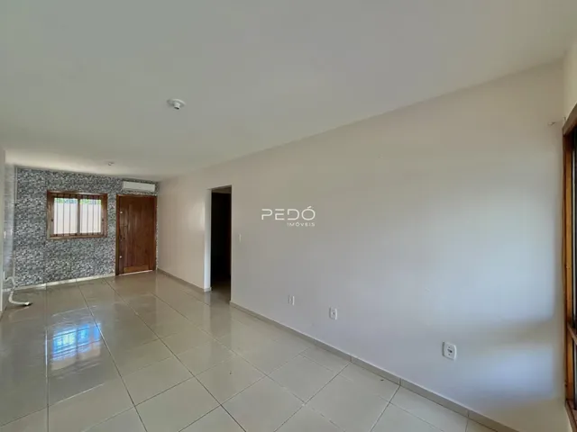 Interior de uma sala com piso de cerâmica e paredes brancas.