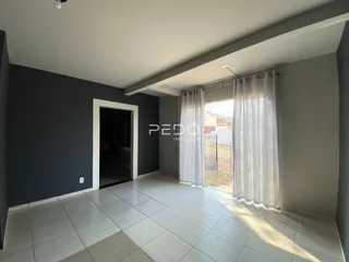 Interior de uma sala com piso de cerâmica e paredes cinzas.