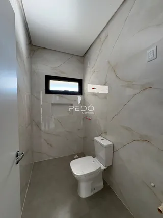 A foto mostra o interior de um banheiro com revestimento de mármore.