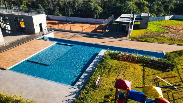 Área externa com piscina e playground em uma propriedade em Lajeado.