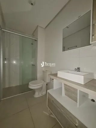 Foto de um banheiro moderno com louças sanitárias brancas.