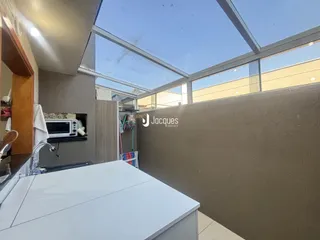 Vista interna de um imóvel com teto de vidro e paredes em tom neutro.