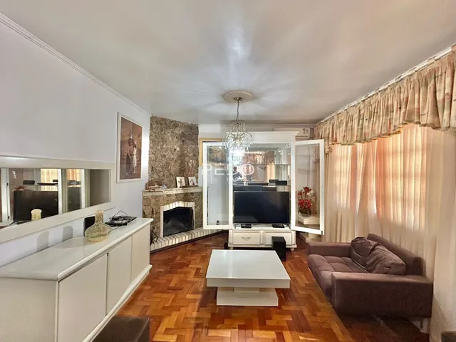 Sala de estar com piso de madeira e lareira em ambiente claro.