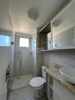 Banheiro com piso cerâmico e bancada de granito