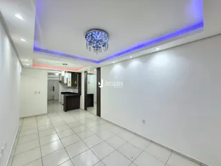 Hall de entrada com piso de cerâmica clara e paredes brancas.