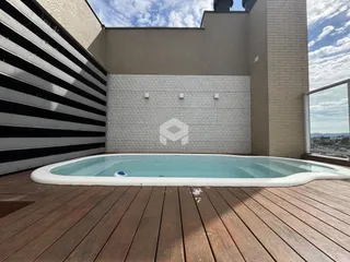 Área externa com piscina e deck de madeira.