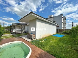 Fachada de uma residência com piscina e jardim em Lajeado.