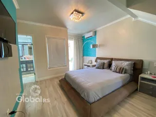 Quarto com cama e piso de madeira em um imóvel no Brasil.
