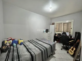 Quarto com cama e armário branco em um imóvel no Brasil.