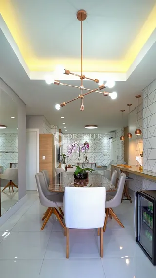 Foto de uma sala de jantar moderna com mesa de vidro e luminária pendente.