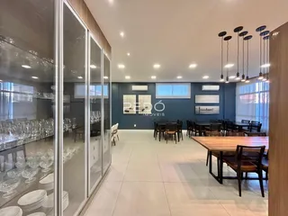 Interior de uma sala de jantar ampla com piso claro e paredes azuis.