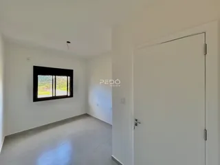 Ambiente interno de uma sala com parede branca e piso claro.