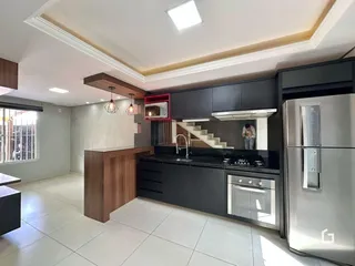 Foto de uma cozinha moderna com armários escuros e bancadas pretas.