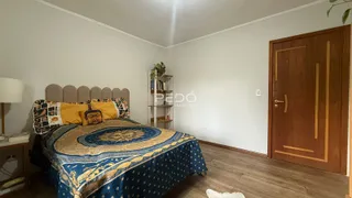 Quarto com cama e porta de madeira em uma residência.