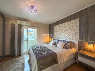 Quarto com cama grande e cortinas em um imóvel no Brasil.