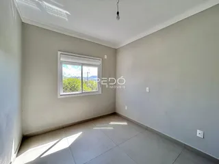 Ambiente interno de uma sala com piso de cerâmica e janela.