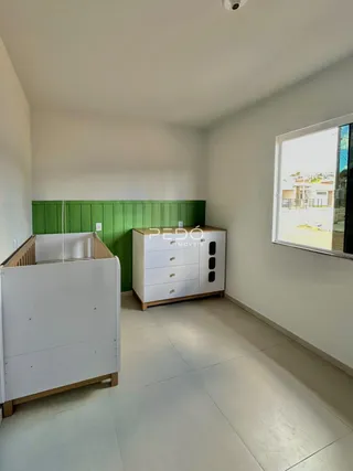 Ambiente interno com paredes brancas e destaque verde na sala.