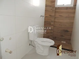 Banheiro com revestimento branco e louças sanitárias.