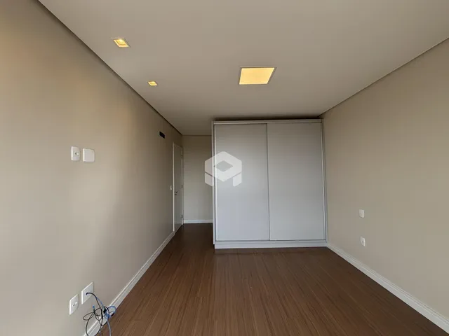 Corredor interno de uma residência com piso de madeira.