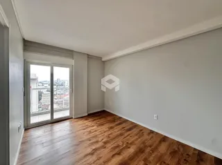 Sala de estar com piso de madeira e porta de vidro.