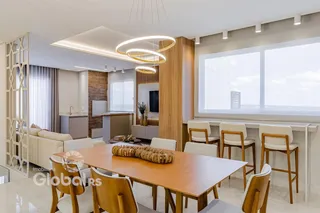 Sala de jantar moderna com mesa de madeira e grandes janelas.