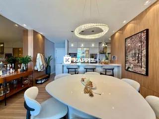 Uma foto de uma sala de jantar moderna com mesa branca e iluminação pendente.