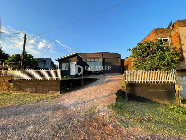 Fachada de uma residência em Lajeado, Brasil, com cerca e entrada de terra.
