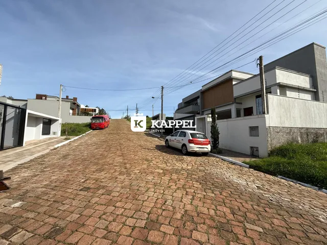 Vista externa da residência com acesso por rua de paralelepípedos.