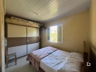 Quarto com cama e janela de madeira.